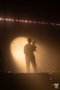 Lucas Saint Cricq en contraste avec le mur de lumière derrière lui